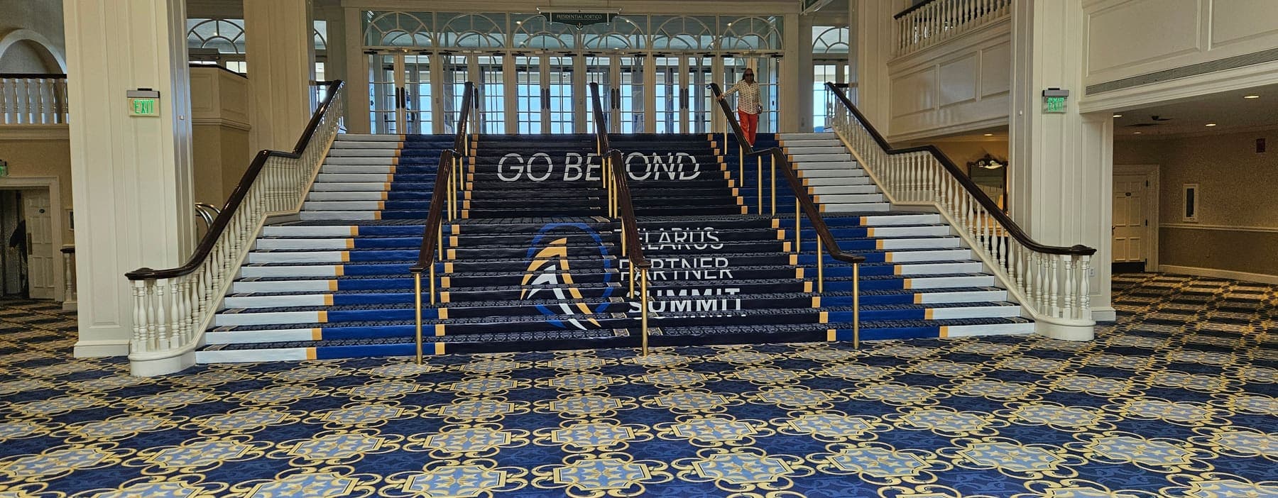 Venue staircase wrapped in navy partner-summit event graphics