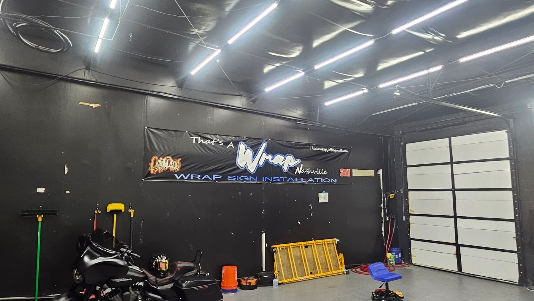 Inside the That's a Wrap Nashville install bay with the shop banner on the wall
